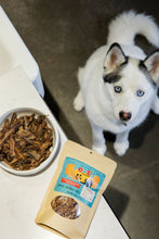 Load image into Gallery viewer, Husky peering up at bowl of single ingredient treats and Pezzy bag on kitchen counter.

